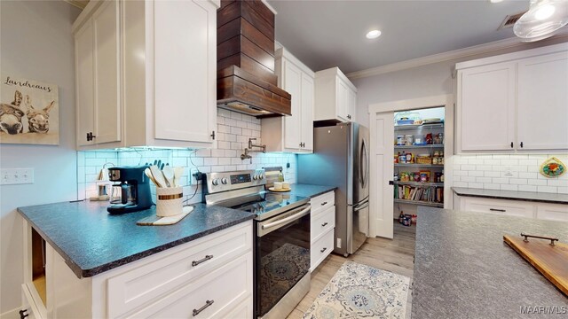 3063 Little Rd, Tallassee, AL 36078 - kitchen with appliances with stainless steel finishes, custom exhaust hood, crown molding, white cabinetry, and backsplash