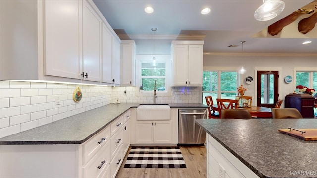 3063 Little Rd, Tallassee, AL 36078 - kitchen with stainless steel dishwasher, a sink, dark countertops, ornamental molding, and light wood finished floors