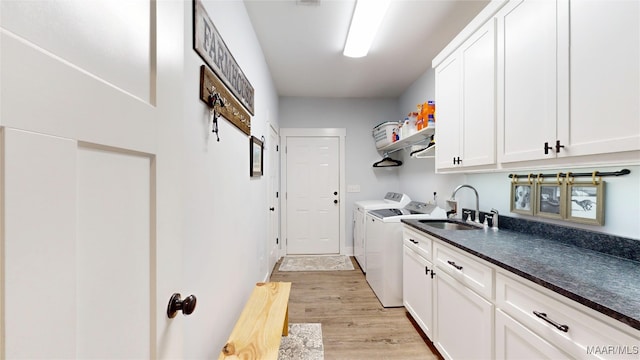 3063 Little Rd, Tallassee, AL 36078 - laundry room featuring independent washer and dryer, cabinet space, and light wood-style flooring