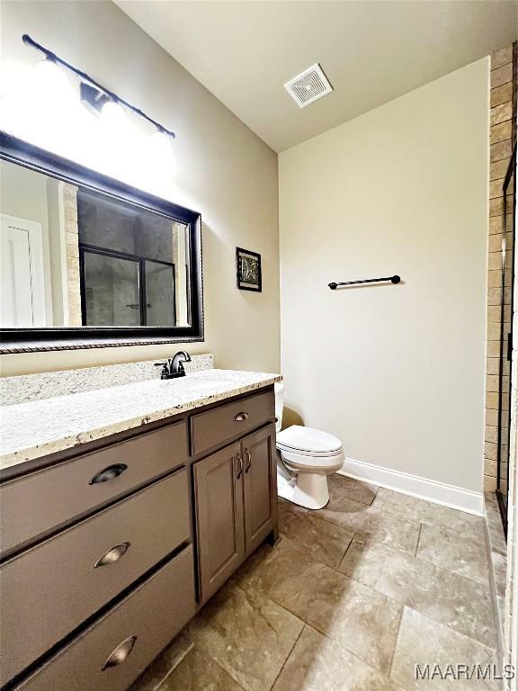 475 Mountain Meadows Ln, Wetumpka, AL 36093 - bathroom with vanity, a tile shower, baseboards, and toilet