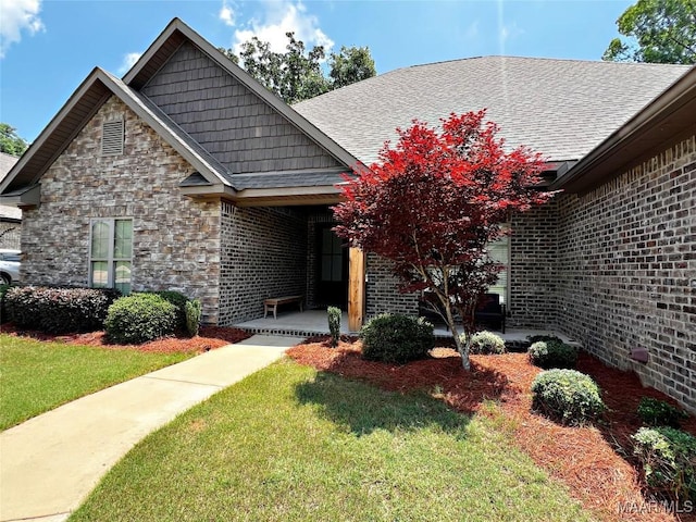 475 Mountain Meadows Ln, Wetumpka, AL 36093 - view of front of home featuring a front lawn, stone siding, a shingled roof, covered porch, and brick siding