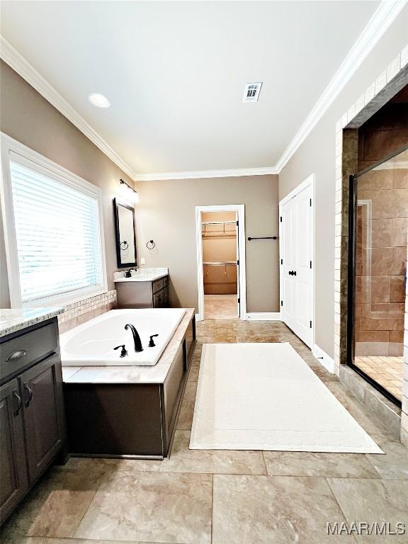 475 Mountain Meadows Ln, Wetumpka, AL 36093 - full bathroom featuring ornamental molding, vanity, a shower stall, a bath, and a walk in closet