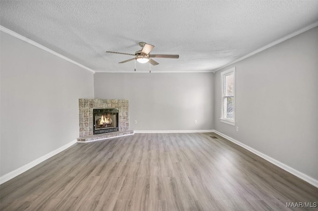 21 Judge Ests, Hope Hull, AL 36043 - unfurnished living room with crown molding, a ceiling fan, a textured ceiling, wood finished floors, and a lit fireplace
