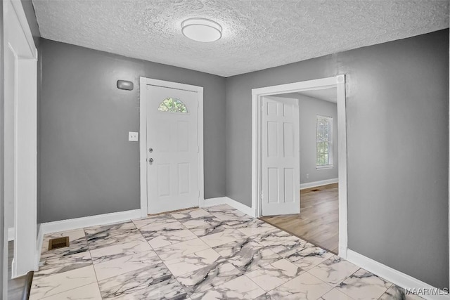 21 Judge Ests, Hope Hull, AL 36043 - foyer featuring baseboards, healthy amount of natural light, light marble finish flooring, and a textured ceiling
