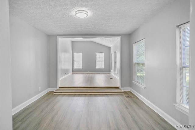 21 Judge Ests, Hope Hull, AL 36043 - empty room with wood finished floors, a textured ceiling, baseboards, and vaulted ceiling