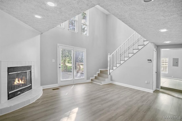 21 Judge Ests, Hope Hull, AL 36043 - unfurnished living room with wood finished floors, stairs, a tile fireplace, baseboards, and recessed lighting