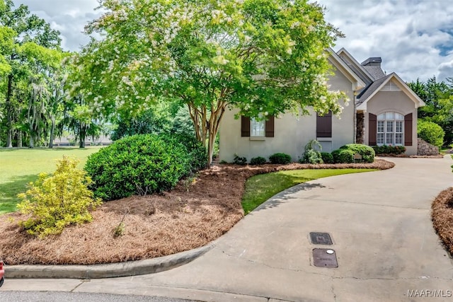 3900 Turning Leaf Loop, Montgomery, AL 36116 - obstructed view of property featuring stucco siding, a front lawn, and a chimney