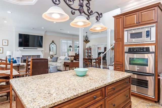 3900 Turning Leaf Loop, Montgomery, AL 36116 - kitchen with appliances with stainless steel finishes, light stone countertops, brown cabinetry, crown molding, and a center island