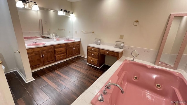 610 Booth Rd, Montgomery, AL 36108 - bathroom featuring double vanity, a whirlpool tub, and wood finished floors