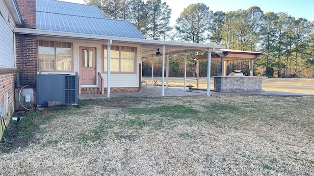 610 Booth Rd, Montgomery, AL 36108 - view of grassy yard featuring ceiling fan, central AC unit, an attached carport, entry steps, and a patio area