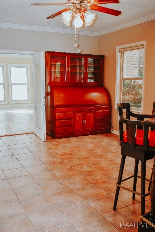 813 Lake Region Cir, Wetumpka, AL 36092 - dining area with a ceiling fan, crown molding, light tile patterned floors, and a textured ceiling