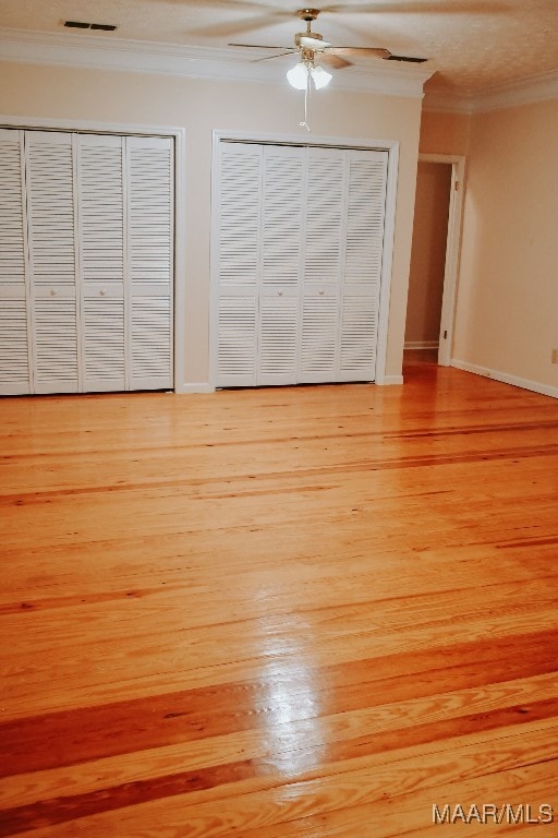 813 Lake Region Cir, Wetumpka, AL 36092 - unfurnished bedroom with crown molding, two closets, light wood-type flooring, ceiling fan, and baseboards