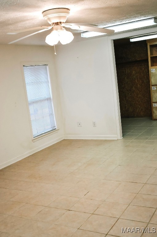 813 Lake Region Cir, Wetumpka, AL 36092 - empty room featuring light tile patterned flooring, a ceiling fan, baseboards, and a textured ceiling