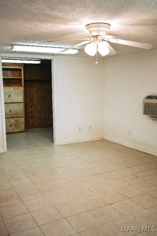 813 Lake Region Cir, Wetumpka, AL 36092 - unfurnished room featuring a textured ceiling, a wall mounted AC, a ceiling fan, and baseboards