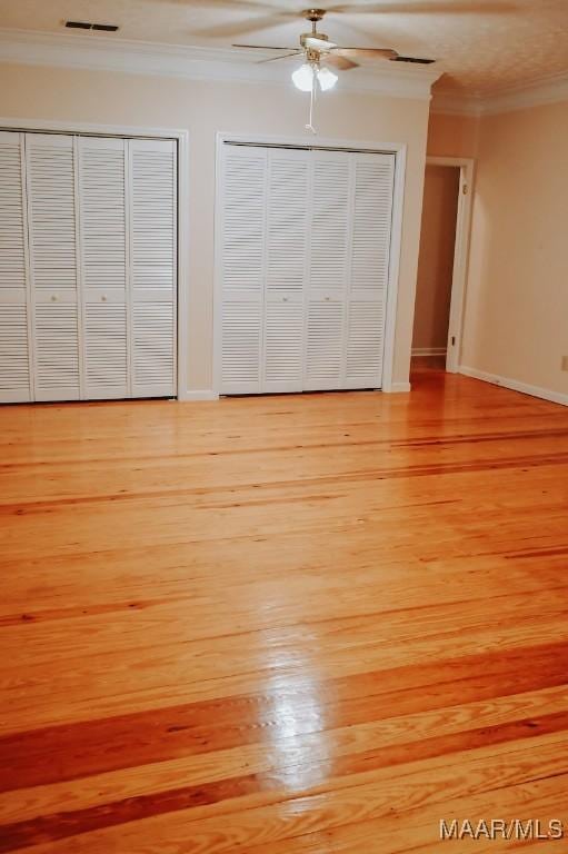 813 Lake Region Cir, Wetumpka, AL 36092 - unfurnished bedroom with crown molding, two closets, light wood-style flooring, and a ceiling fan