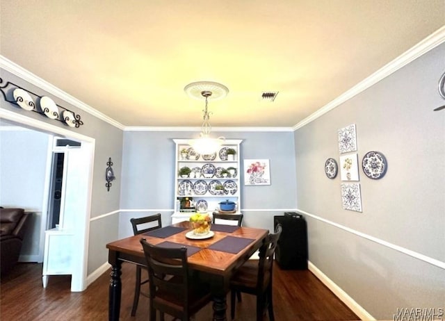 1915 Mckinley Ave, Montgomery, AL 36107 - dining space with dark wood-type flooring, crown molding, baseboards, and built in shelves