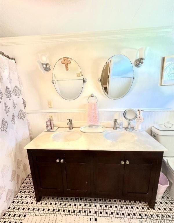 1915 Mckinley Ave, Montgomery, AL 36107 - full bathroom featuring double vanity, toilet, wallpapered walls, and wainscoting
