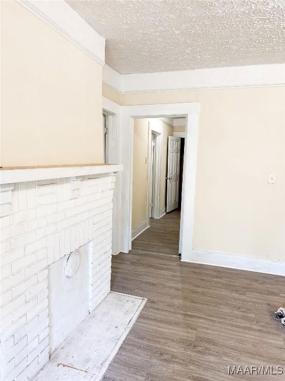 1422 S Holt St, Montgomery, AL 36108 - unfurnished living room with wood finished floors, baseboards, and a textured ceiling