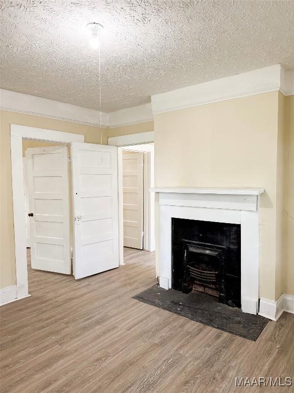 1422 S Holt St, Montgomery, AL 36108 - detailed view of wood finished floors, a fireplace with flush hearth, a textured ceiling, and baseboards