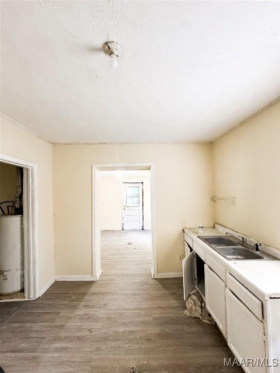 1422 S Holt St, Montgomery, AL 36108 - hall with gas water heater, a sink, wood finished floors, and baseboards