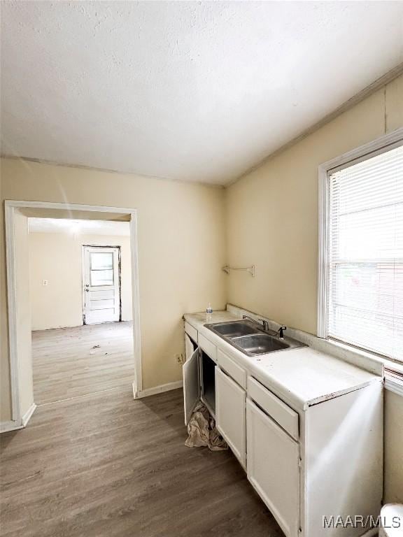 1422 S Holt St, Montgomery, AL 36108 - kitchen featuring a sink, dark wood-style floors, white cabinets, light countertops, and baseboards