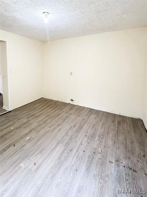 1422 S Holt St, Montgomery, AL 36108 - unfurnished room featuring wood finished floors and a textured ceiling
