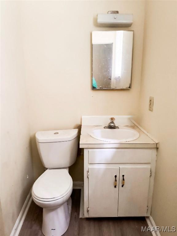 1422 S Holt St, Montgomery, AL 36108 - bathroom with vanity, toilet, wood finished floors, and baseboards