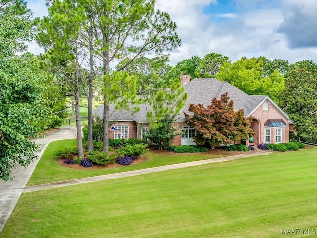 8054 Lakeridge Dr, Montgomery, AL 36117 - view of front facade featuring brick siding, a front yard, and a chimney