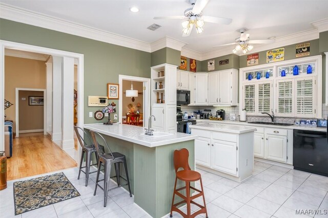 8054 Lakeridge Dr, Montgomery, AL 36117 - kitchen featuring black appliances, a sink, a center island with sink, ceiling fan, and white cabinetry