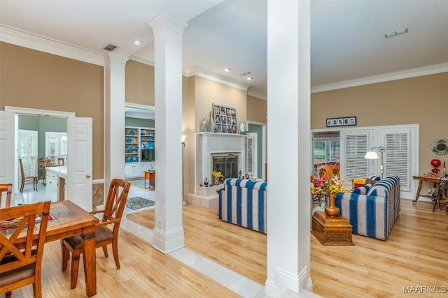 8054 Lakeridge Dr, Montgomery, AL 36117 - dining area with ornamental molding, light wood-style flooring, decorative columns, a fireplace with raised hearth, and recessed lighting