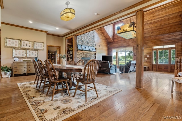 511 Mehearg Rd, Wetumpka, AL 36092 - dining area with lofted ceiling, wood walls, light wood finished floors, a stone fireplace, and ornamental molding