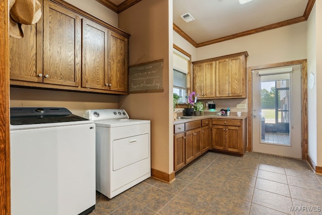 511 Mehearg Rd, Wetumpka, AL 36092 - washroom featuring washer and dryer, crown molding, cabinet space, and dark tile patterned floors