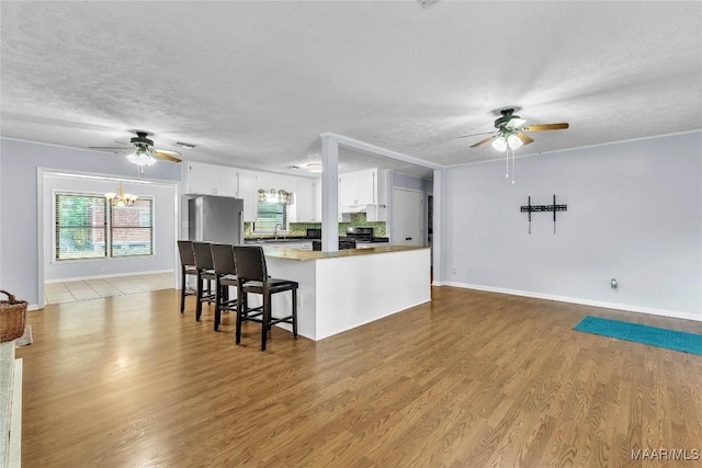 211 Murfee Dr, Prattville, AL 36066 - kitchen with refrigerator, a ceiling fan, black electric range, a textured ceiling, and white cabinets