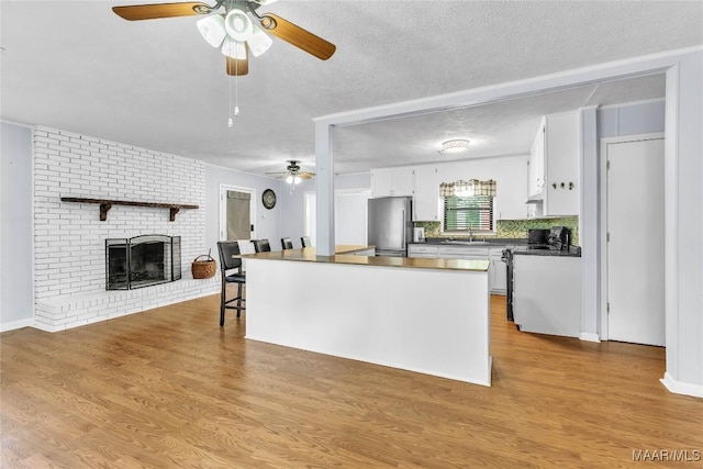 211 Murfee Dr, Prattville, AL 36066 - kitchen with freestanding refrigerator, range, ceiling fan, dark countertops, and white cabinetry