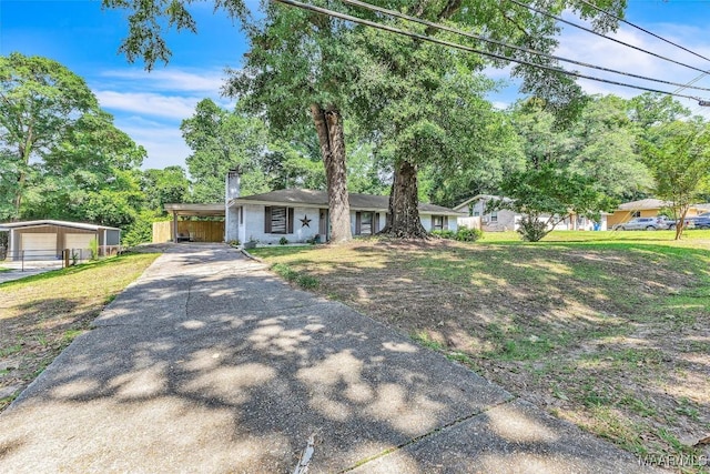211 Murfee Dr, Prattville, AL 36066 - ranch-style home featuring concrete driveway, a chimney, a carport, an outdoor structure, and a front yard