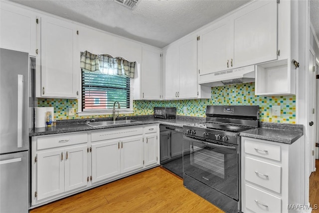 211 Murfee Dr, Prattville, AL 36066 - kitchen with black range with electric cooktop, under cabinet range hood, a sink, freestanding refrigerator, and a textured ceiling