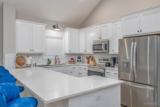 365 Wrightsburg Cir, Wetumpka, AL 36093 - kitchen featuring appliances with stainless steel finishes, a sink, vaulted ceiling, tasteful backsplash, and a kitchen breakfast bar