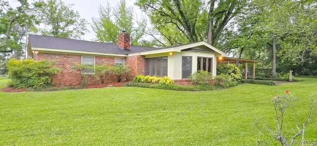 2728 Oxford Dr, Montgomery, AL 36111 - back of house with a chimney, a lawn, brick siding, and a sunroom