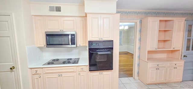 2728 Oxford Dr, Montgomery, AL 36111 - kitchen featuring black oven, stainless steel microwave, electric cooktop, light countertops, and crown molding