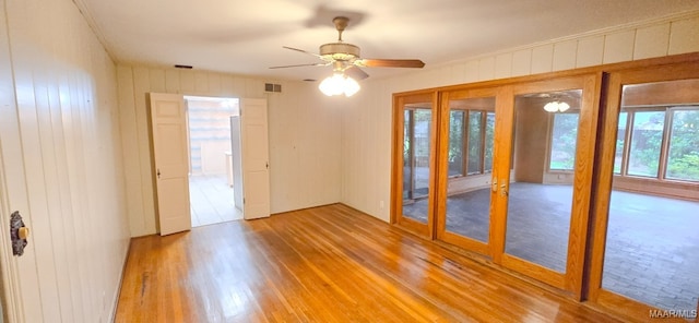 2728 Oxford Dr, Montgomery, AL 36111 - empty room with wood finished floors, a ceiling fan, wood walls, and french doors