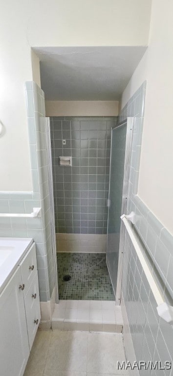 2728 Oxford Dr, Montgomery, AL 36111 - bathroom featuring tile walls, a shower stall, vanity, tile patterned flooring, and wainscoting