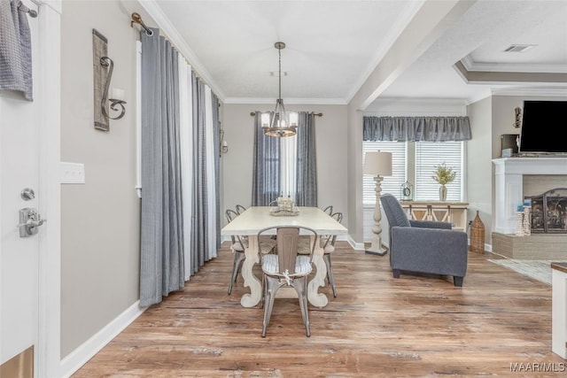 28 Lake Region Dr, Wetumpka, AL 36092 - dining room featuring light wood-style floors, a chandelier, baseboards, ornamental molding, and a fireplace