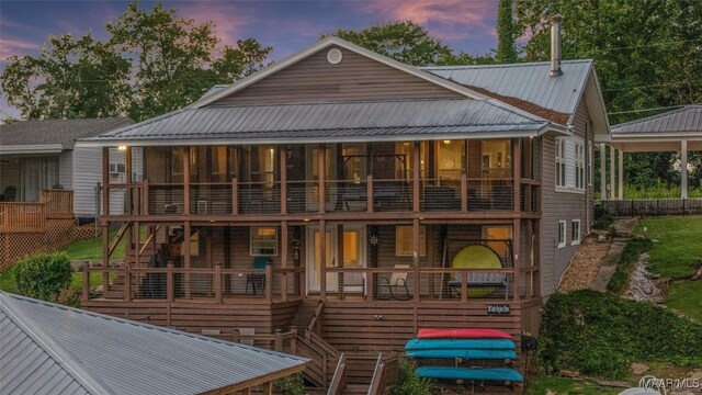 28 Lake Region Dr, Wetumpka, AL 36092 - back of house at dusk with stairway, metal roof, and a sunroom