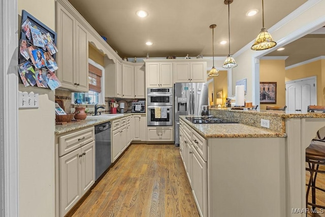 18490 US Highway 31st Rd, Clanton, AL 35045 - kitchen with stainless steel appliances, ornamental molding, a kitchen breakfast bar, light wood-style floors, and pendant lighting
