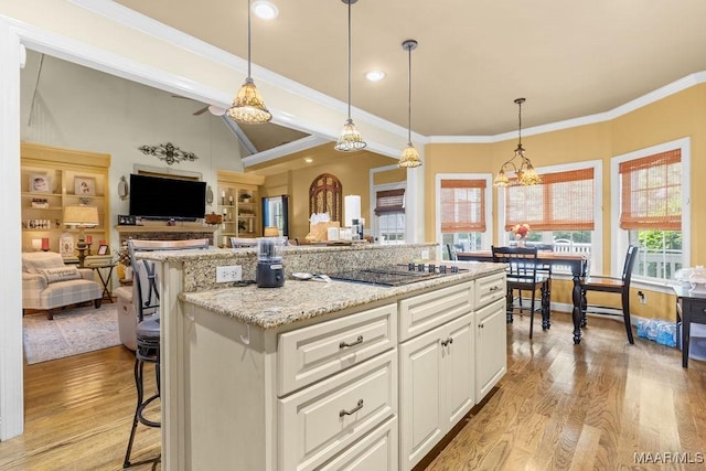 18490 US Highway 31st Rd, Clanton, AL 35045 - kitchen with light wood finished floors, a kitchen bar, white cabinetry, healthy amount of natural light, and ornamental molding