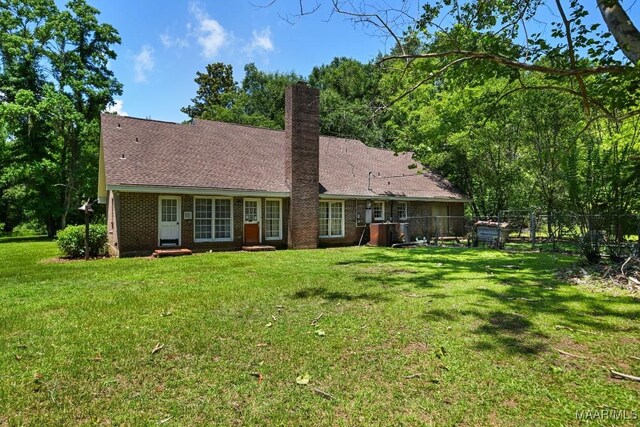 76 Willow Springs Rd, Wetumpka, AL 36093 - back of house with a chimney, brick siding, and roof with shingles