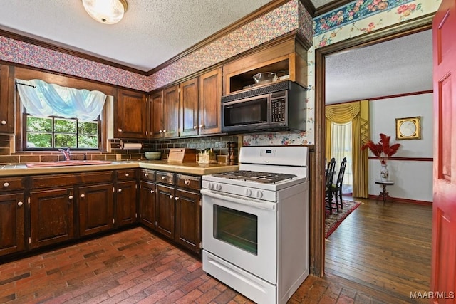 76 Willow Springs Rd, Wetumpka, AL 36093 - kitchen featuring gas range gas stove, black microwave, a textured ceiling, crown molding, and tasteful backsplash