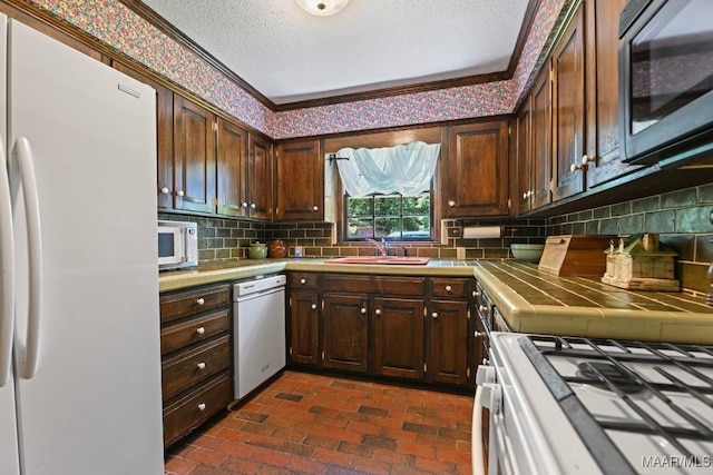 76 Willow Springs Rd, Wetumpka, AL 36093 - kitchen featuring stainless steel appliances, tile countertops, brick floors, ornamental molding, and backsplash