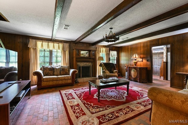 76 Willow Springs Rd, Wetumpka, AL 36093 - living area with plenty of natural light, a textured ceiling, wood walls, brick floors, and a fireplace with raised hearth