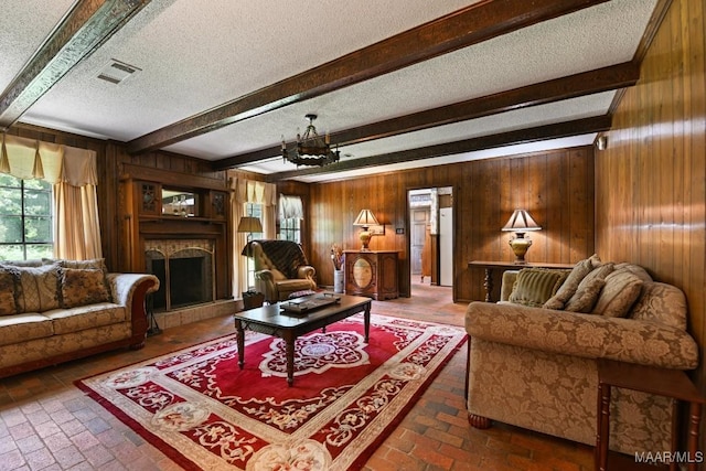 76 Willow Springs Rd, Wetumpka, AL 36093 - living room with brick flooring, a textured ceiling, wood walls, a fireplace with raised hearth, and a chandelier